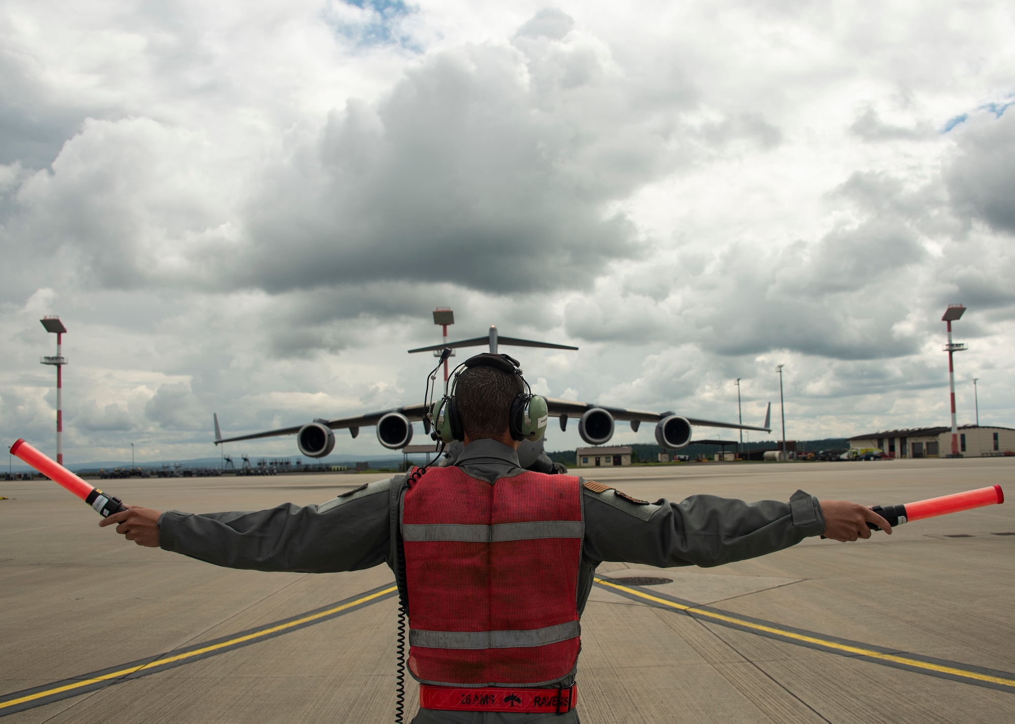U.S. Air Force Senior Airman Alberto Lara, 726th AMS crew chief, marshals a C-17 Globemaster III cargo aircraft on Spangdahlem Air Base, Germany, Aug. 5, 2021.