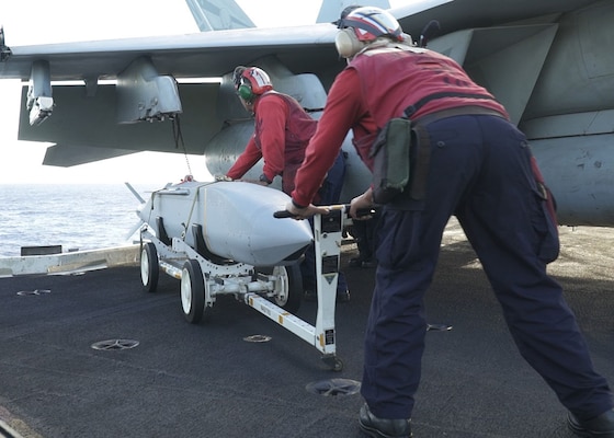 Sailors aboard USS Carl Vinson (CVN 70) load munitions for a sinking exercise.
