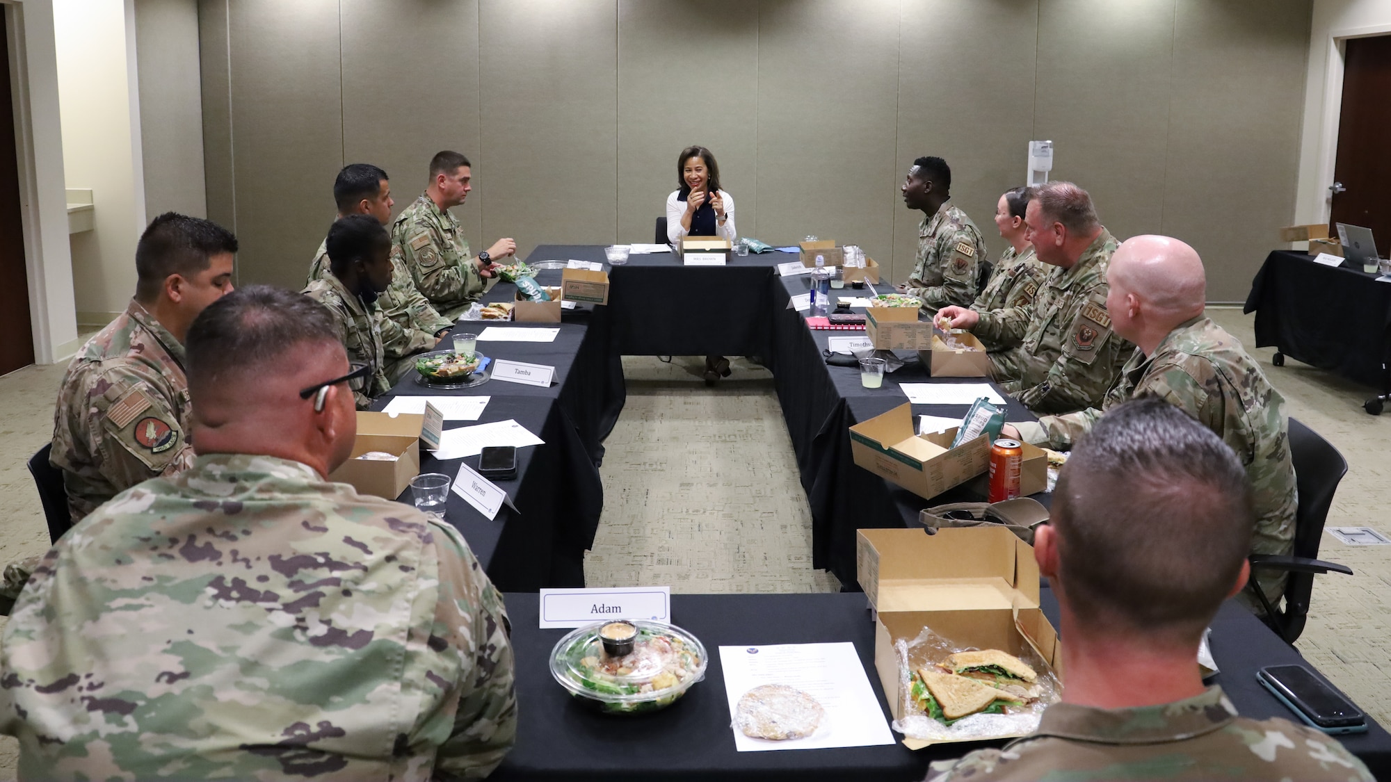 Men and women sitting around a table having lunch