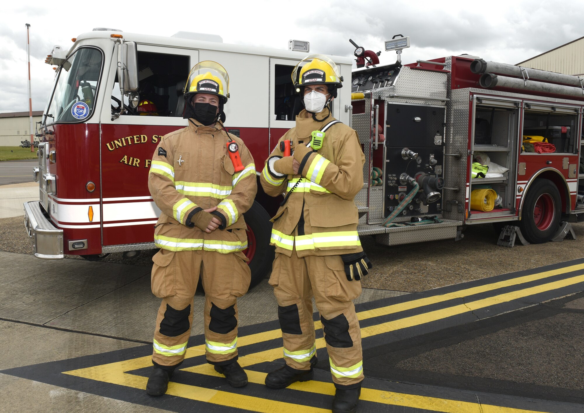 U.S. Air Force Airman 1st Class Adam Luke, left, and Airman Robert Cataldo, both 100th Civil Engineer Squadron firefighters, pose for a photo by a fire truck at the Diversity and Inclusion Day event at Royal Air Force Mildenhall, England, Aug. 13, 2021. The event included a variety of performances, food and informational booths, a fire truck, Humvee and various static aircraft. (U.S. Air Force photo by Karen Abeyasekere)