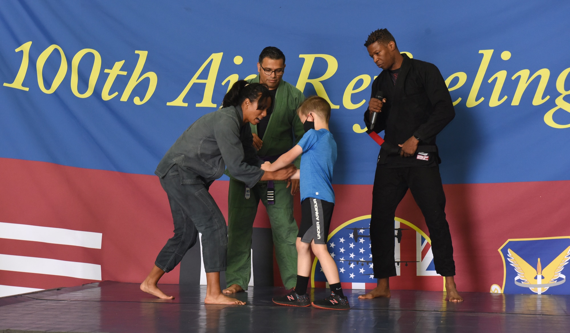 Lincoln Glascock, center, son of Chief Master Sgt. Kathi Glascock, takes a turn to participate in the Jiujitsu demonstration during Diversity and Inclusion Day at Royal Air Force Mildenhall, England, Aug. 13, 2021. The event included a variety of performances, food and informational booths, a fire truck, Humvee and various static aircraft. (U.S. Air Force photo by Karen Abeyasekere)