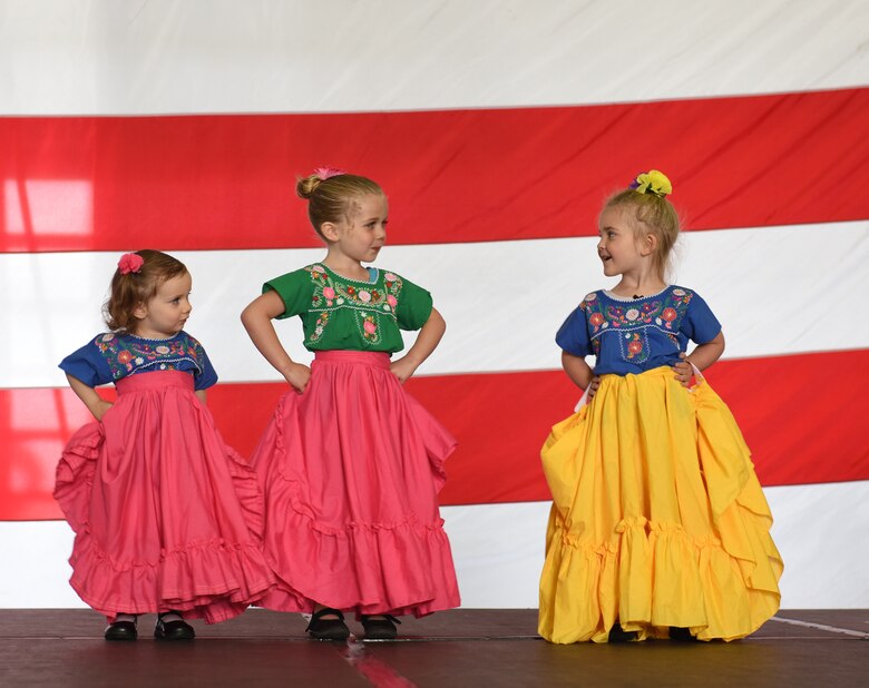 Children of Team Mildenhall members perform as part of the Spouse 2 Spouse Folkloric Dance displays at the Diversity and Inclusion Day event at Royal Air Force Mildenhall, England, Aug. 13, 2021. The event included a variety of performances, food and informational booths, a fire truck, Humvee and static aircraft. (U.S. Air Force photo by Karen Abeyasekere)