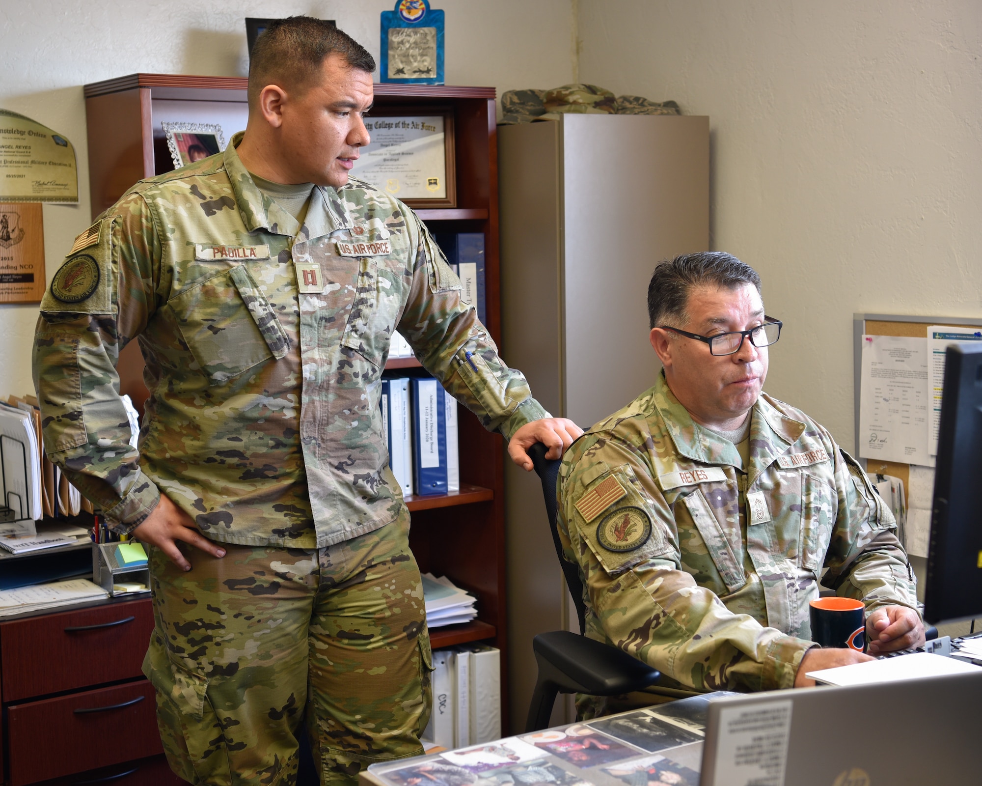 Capt. Rudy Padilla, deputy staff judge advocate, and Senior Master Sgt. Angel Reyes, law office superintendent, review slides for a training presentation