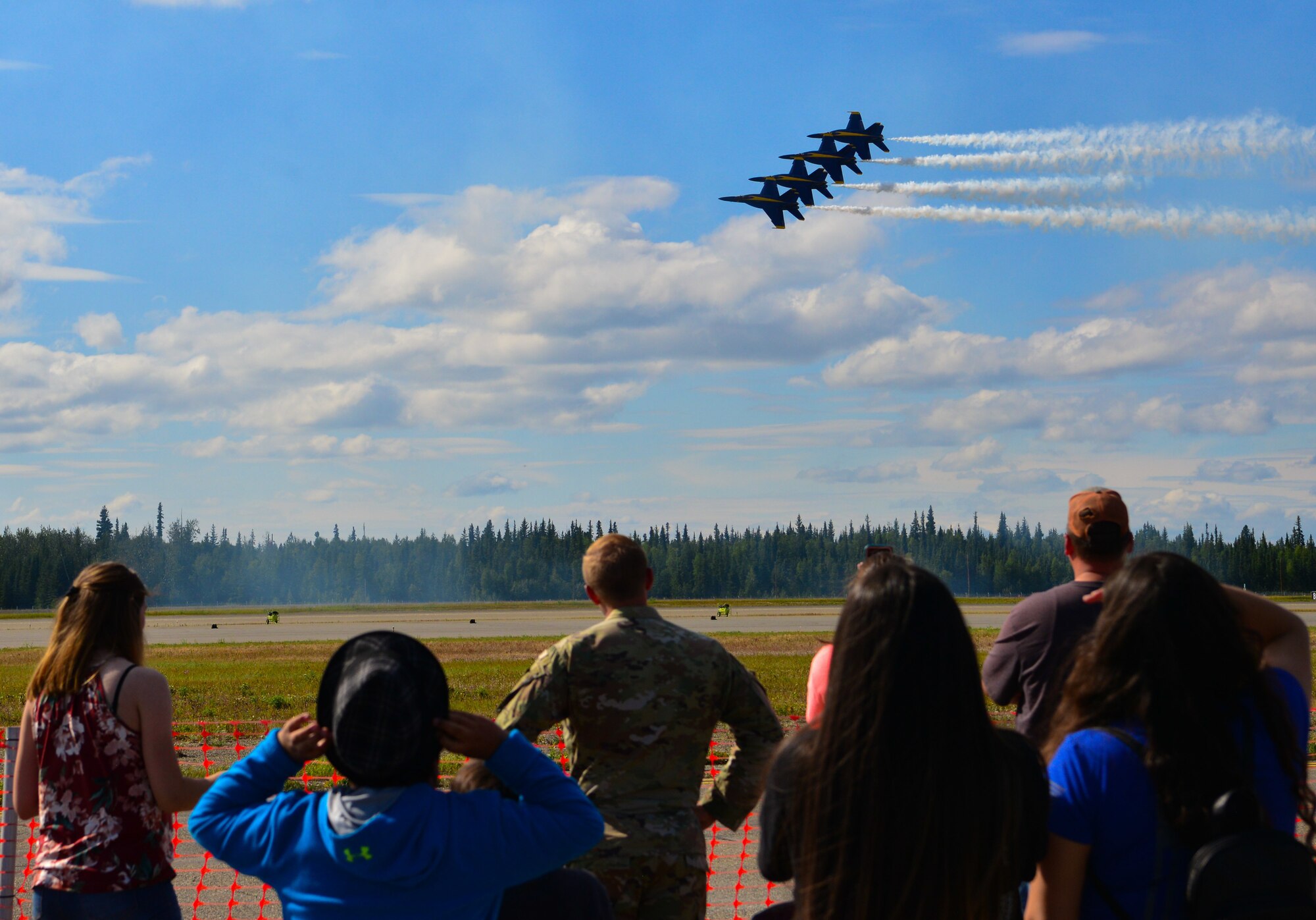 A crowd watches the U.S. Navy Air Demonstration Squadron, the Blue Angels, perform at the 2021 Arctic Lightning Airshow July 30th, 2021, on Eielson Air Force Base, Alaska.