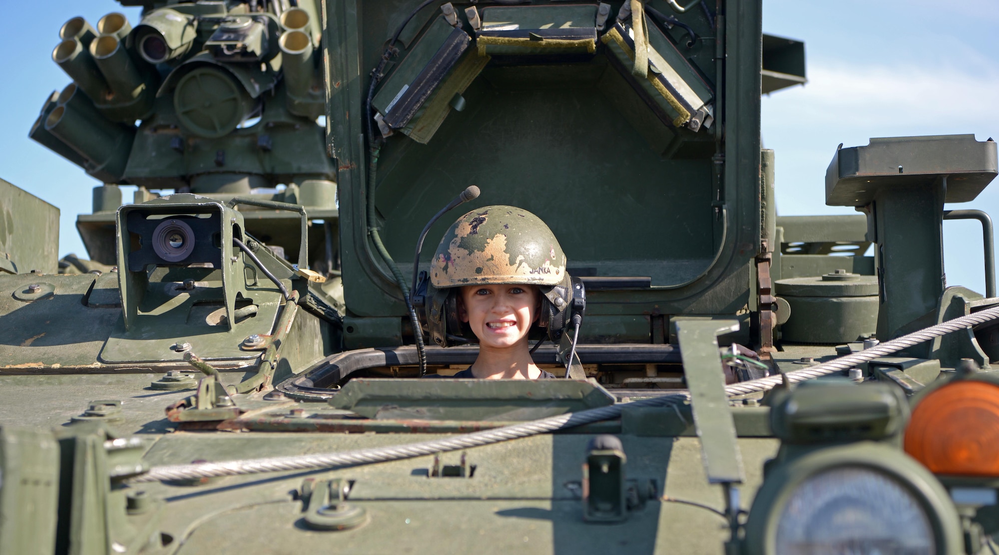 A child smiles for a photo in a U.S. Army vehicle static display during the Arctic Lightning Airshow July 31, 2021, one Eielson Air Force Base, Alaska.