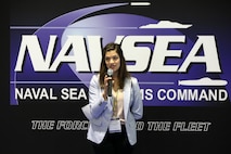 A woman holds a microphone and speaks.