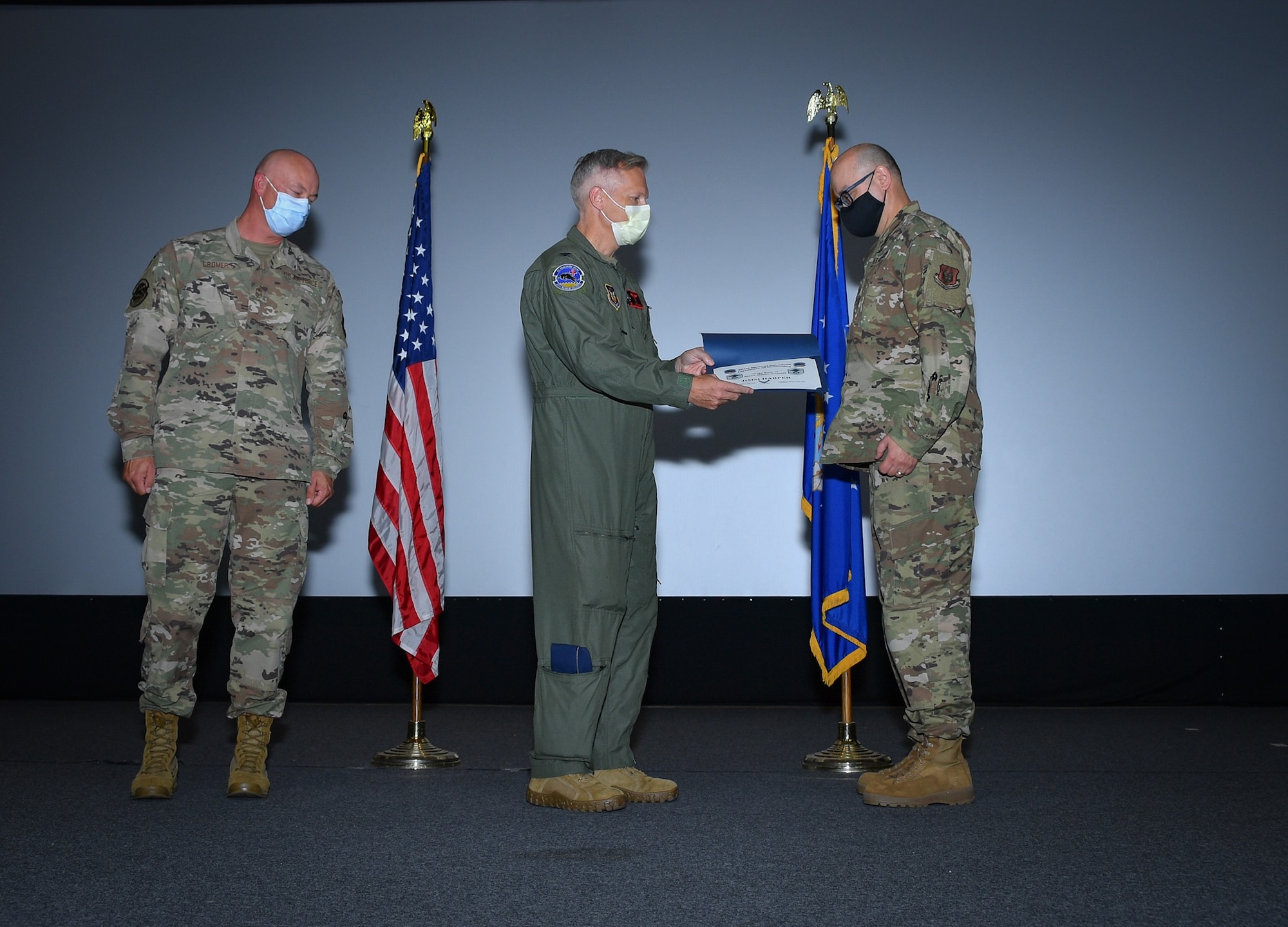 (center) 301 FW MDS Commander Col. Lawson Copley hands an enlisted promotion certificate to Senior Master Sgt. Jimm Harper during an MDS enlisted promotion ceremony at NAS JRB Fort Worth on August 8, 2021. Less than 2% of the enlisted force achieve the grade of E-8. (U.S. Air Force photos by Master Sgt. Jeremy Roman)