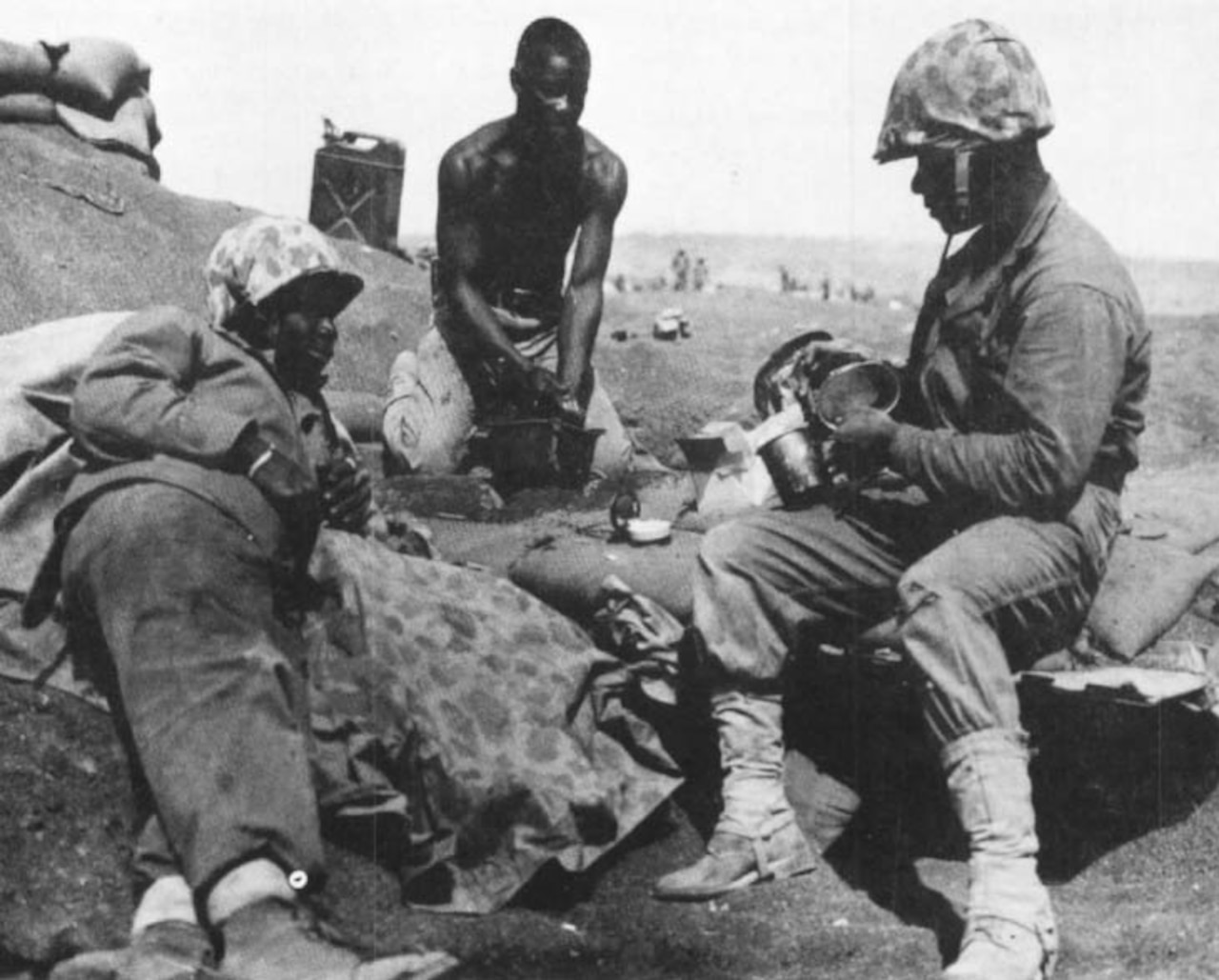 Three Marines take a break on a beach.