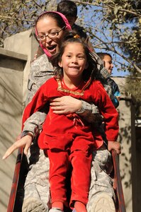 U.S. 1st Lt. Ana Monteiro, 1st Battalion, 101st Field Artillery Regiment (1-101st), Massachusetts Army National Guard, goes down a slide with an Afghan girl at Arian School during a humanitarian aid drop of school supplies on Nov. 10, 2010, in Kabul, Afghanistan. Monteiro and other Soldiers of the 1-101st have 'adopted' the mostly girl school by providing three more classrooms and donating school supplies several times since May