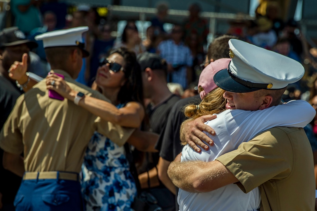 Marine Corps recruits hug family members after a ceremony.