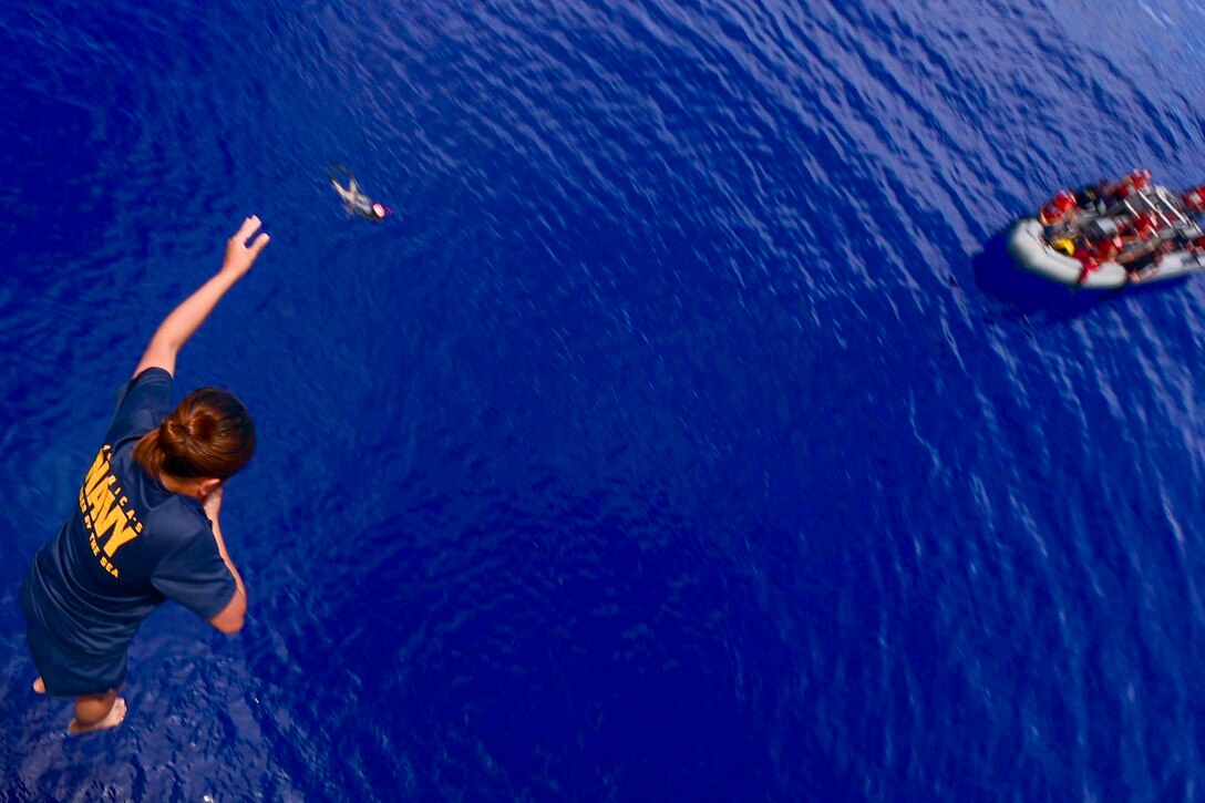 A service member free falls into a body of water.