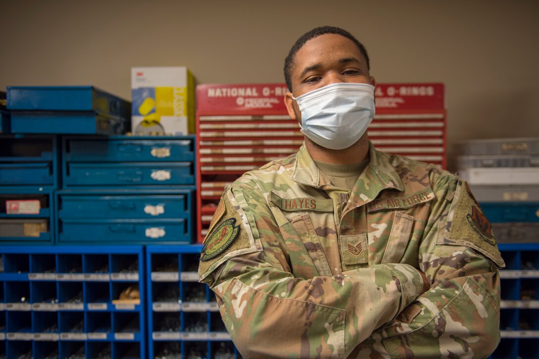 Airman poses for a photo with arms crossed.