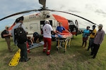 A helicopter lands as seen through the back hatch of another helicopter.