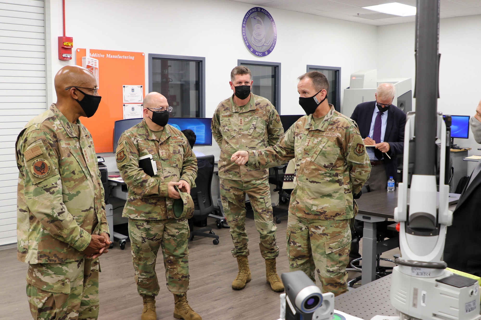 Air Force Chief of Staff Gen. CQ Brown, Jr., Maj. Gen. Jeff King, Oklahoma City Air Logistics Complex commander,  Lt. Gen. Gene Kirkland, Air Force Sustainment Center commander and Lt. Gen. Shaun Morris, Air Force Life Cycle Management Center commander, discuss additive manufacturing efforts with during a tour at Tinker Air Force Base, Okla.,  Aug. 10, 2021.