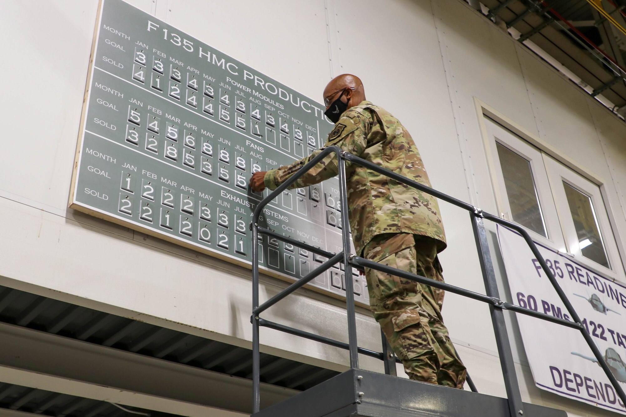 Air Force Chief of Staff Gen. CQ Brown, Jr., updates a production goals board hanging in the F135 engine production area in the Oklahoma City Air Logistics Complex at Tinker Air Force Base, Okla., Aug. 10, 2021.