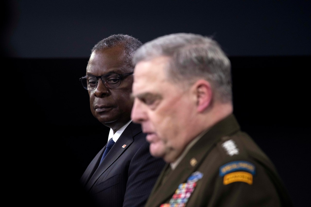 Secretary of Defense Lloyd J. Austin III and Joint Chiefs Chairman Army Gen. Mark A. Milley stand at podium.