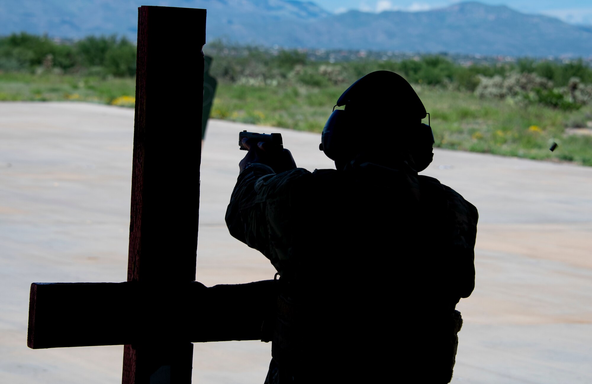 A photo of an airman firing a pistol