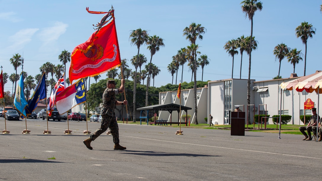 U.S. Marine Corps Master Gunnery Sgt. Jamie Myers, operations chief, 15th Marine Expeditionary Unit, carries the unit colors during a change of command ceremony at Marine Corps Base Camp Pendleton, California, July 21, 2021. The 15th MEU provides a forward deployed, flexible sea-based Marine Air-Ground Task Force capable of conducting Amphibious Operations, crisis response and limited contingency operations, to include enabling the introduction of follow-on forces, and, designated special operations, in order to support the theater requirements of Geographic Combatant Commanders. (U.S. Marine Corps photo by Lance Cpl. Mackenzie Binion)