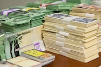 Exercise props, including play currency, EagleCash cards and mock Treasury checks, sit ready for use during Diamond Saber at Fort McCoy, Wisconsin, Aug. 14, 2021. Diamond Saber is a U.S. Army Reserve-led exercise that incorporates participation from all components and joint services, and it prepares finance and comptroller Soldiers on the warfighting functions of funding the force, payment support, disbursing operations, accounting, fiscal stewardship, auditability and data analytics. (U.S. Army photo by Mark R. W. Orders-Woempner)