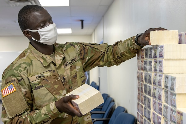 Cadet Serigne Cisse, 374th Financial Management Support Unit officer candidate, stacks play currency for Diamond Saber at Fort McCoy, Wisconsin, Aug. 14, 2021. Diamond Saber is a U.S. Army Reserve-led exercise that incorporates participation from all components and joint services, and it prepares finance and comptroller Soldiers on the warfighting functions of funding the force, payment support, disbursing operations, accounting, fiscal stewardship, auditability and data analytics. (U.S. Army photo by Mark R. W. Orders-Woempner)