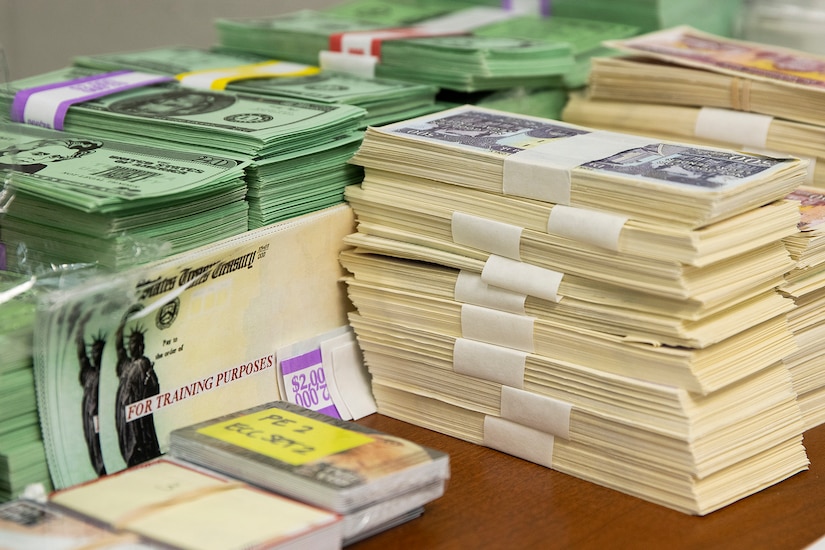 Exercise props, including play currency, EagleCash cards and mock Treasury checks, sit ready for use during Diamond Saber at Fort McCoy, Wisconsin, Aug. 14, 2021. Diamond Saber is a U.S. Army Reserve-led exercise that incorporates participation from all components and joint services, and it prepares finance and comptroller Soldiers on the warfighting functions of funding the force, payment support, disbursing operations, accounting, fiscal stewardship, auditability and data analytics. (U.S. Army photo by Mark R. W. Orders-Woempner)