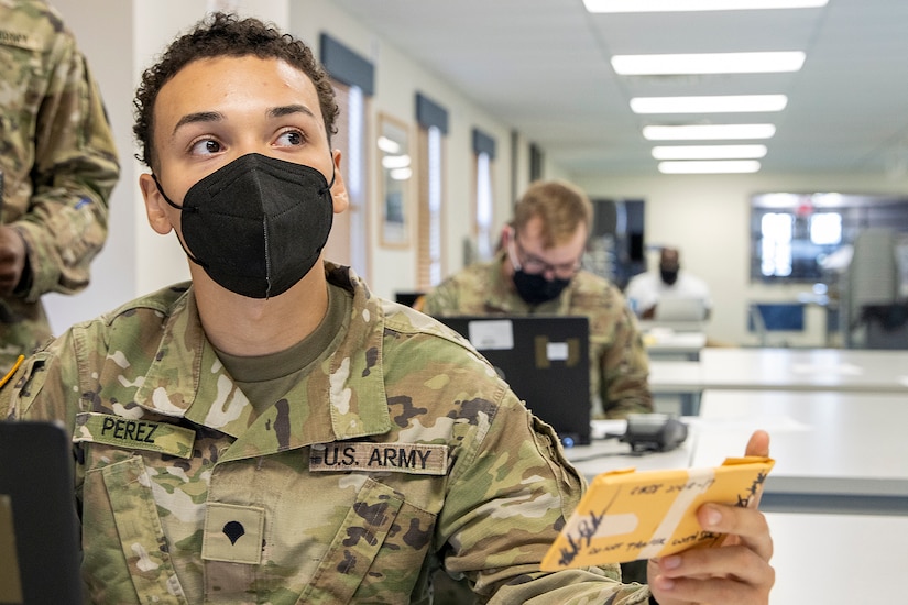 Spc. Domingo Perez-Lopez, 395th Financial Management Support Unit financial management specialist, receives simulated captured currency during Diamond Saber at Fort McCoy, Wisconsin, Aug. 14, 2021. Diamond Saber is a U.S. Army Reserve-led exercise that incorporates participation from all components and joint services, and it prepares finance and comptroller Soldiers on the warfighting functions of funding the force, payment support, disbursing operations, accounting, fiscal stewardship, auditability and data analytics. (U.S. Army photo by Mark R. W. Orders-Woempner)