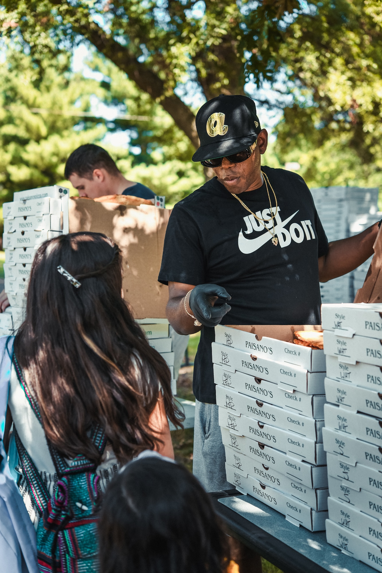 A volunteer hands out free pizza to Joint Base Andrews families at the Community Commons on Joint Base Andrews, Md., Aug. 11, 2021.