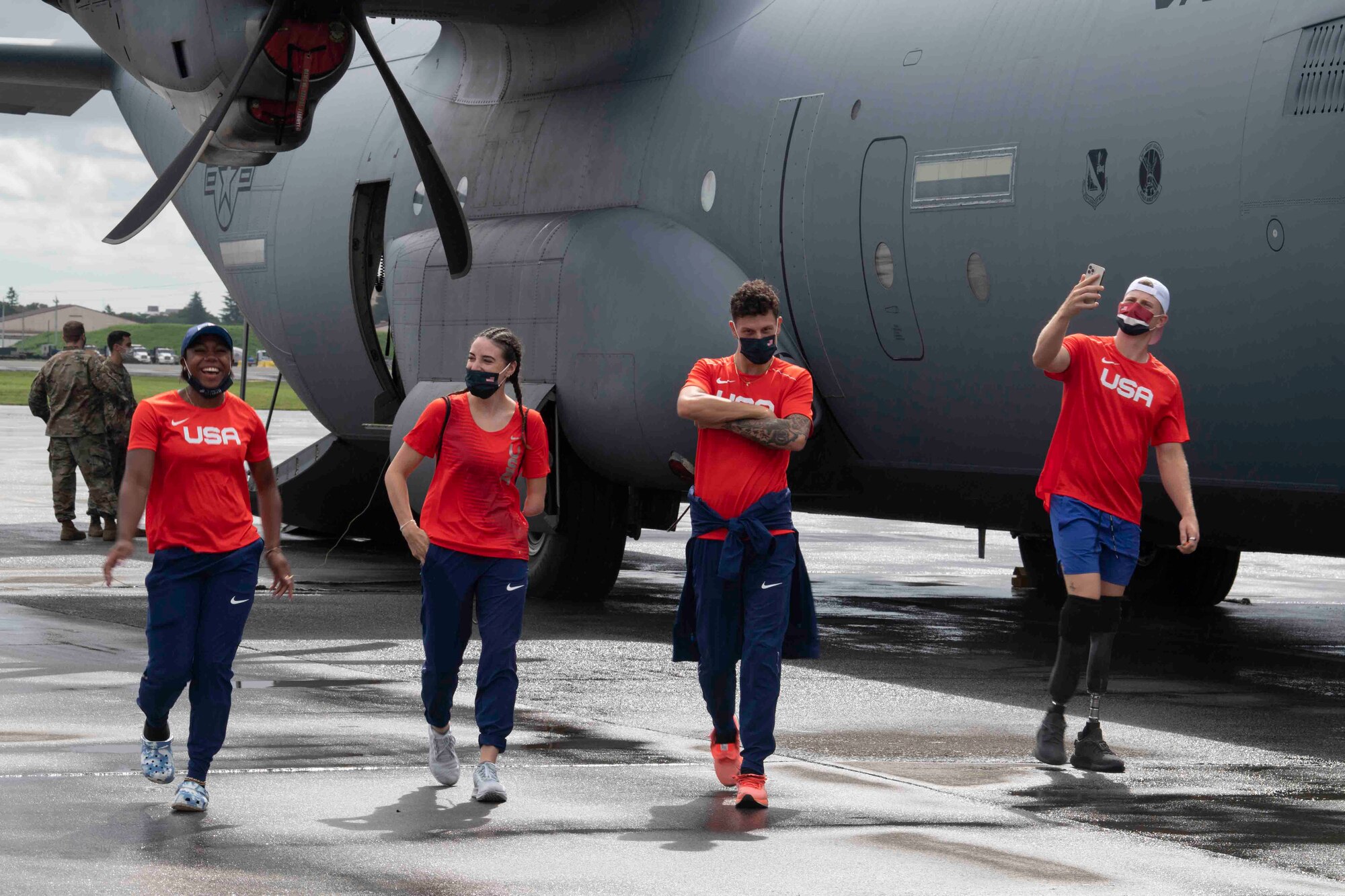 U.S. Paralympians pose in front of a C-130J Super Hercules at Yokota Air Base, Japan, Aug. 18, 2021, before competing in the 2020 Summer Paralympic games in Tokyo.