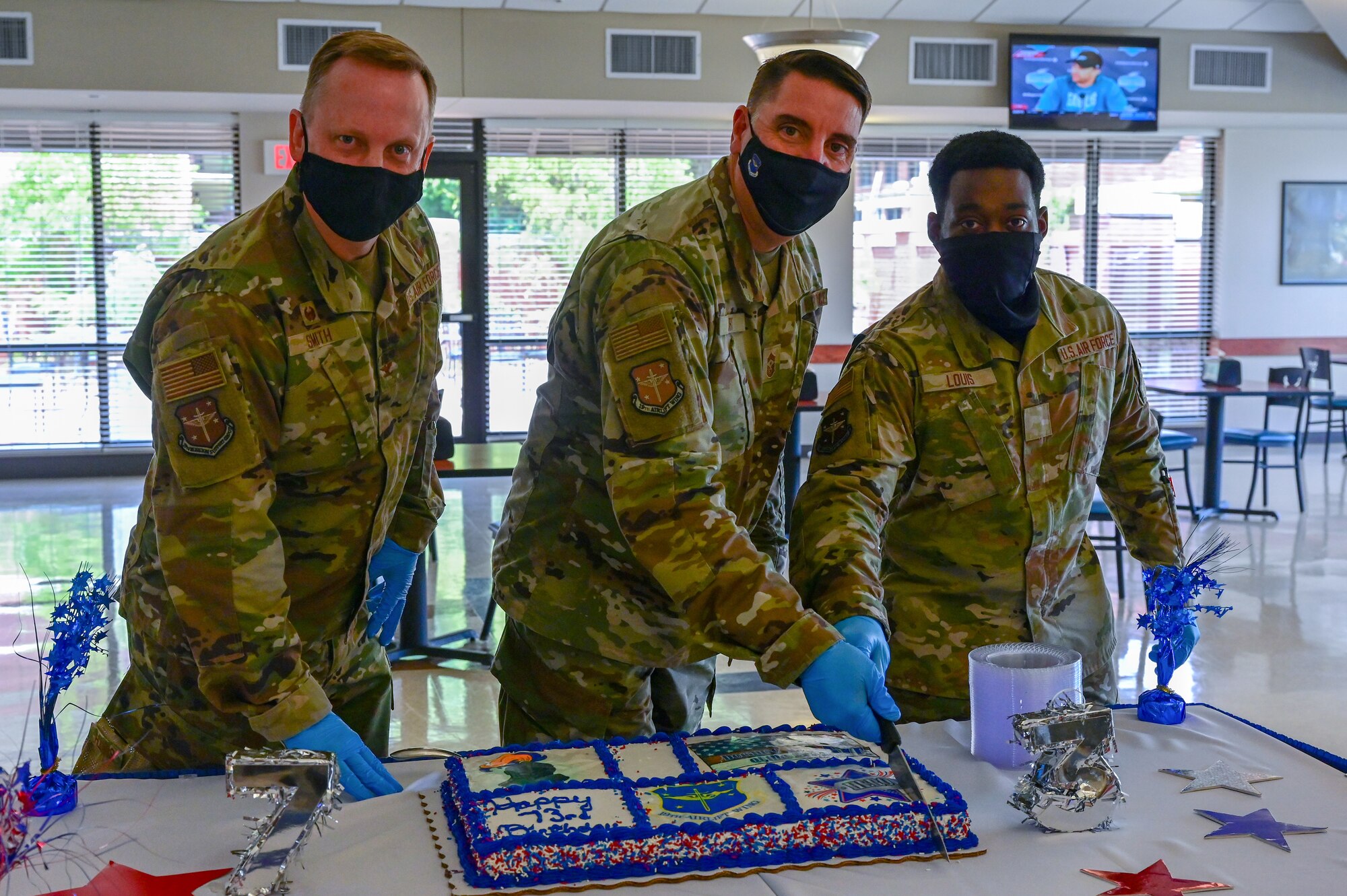 Three Airmen cut a cake