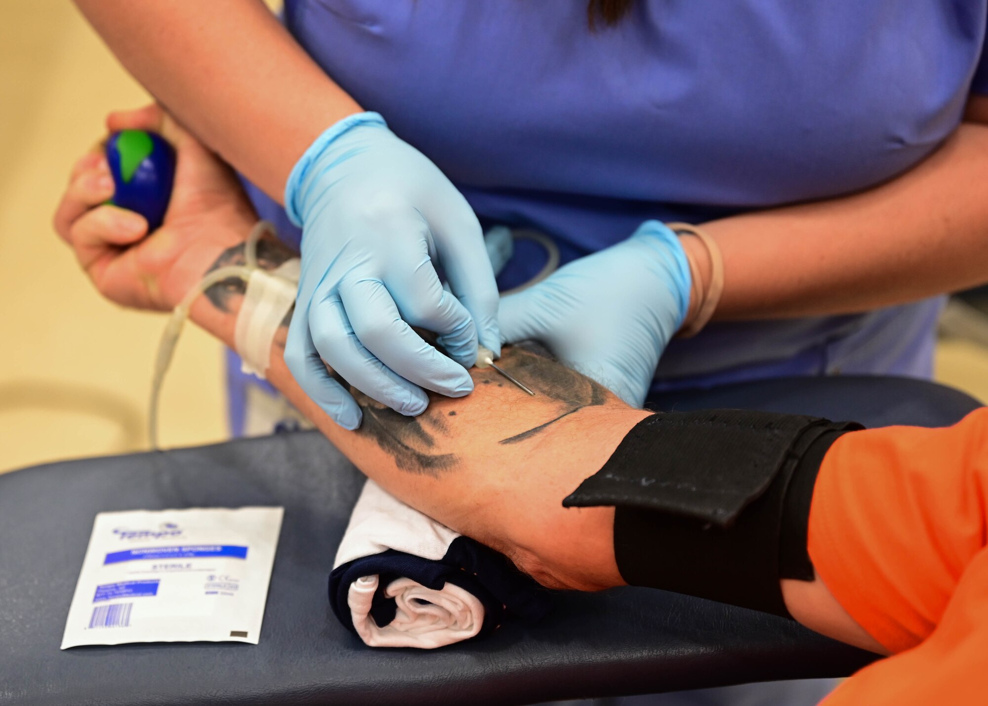 A phlebotomist from the Arkansas Blood Institution draws a volunteer’s blood during a blood drive