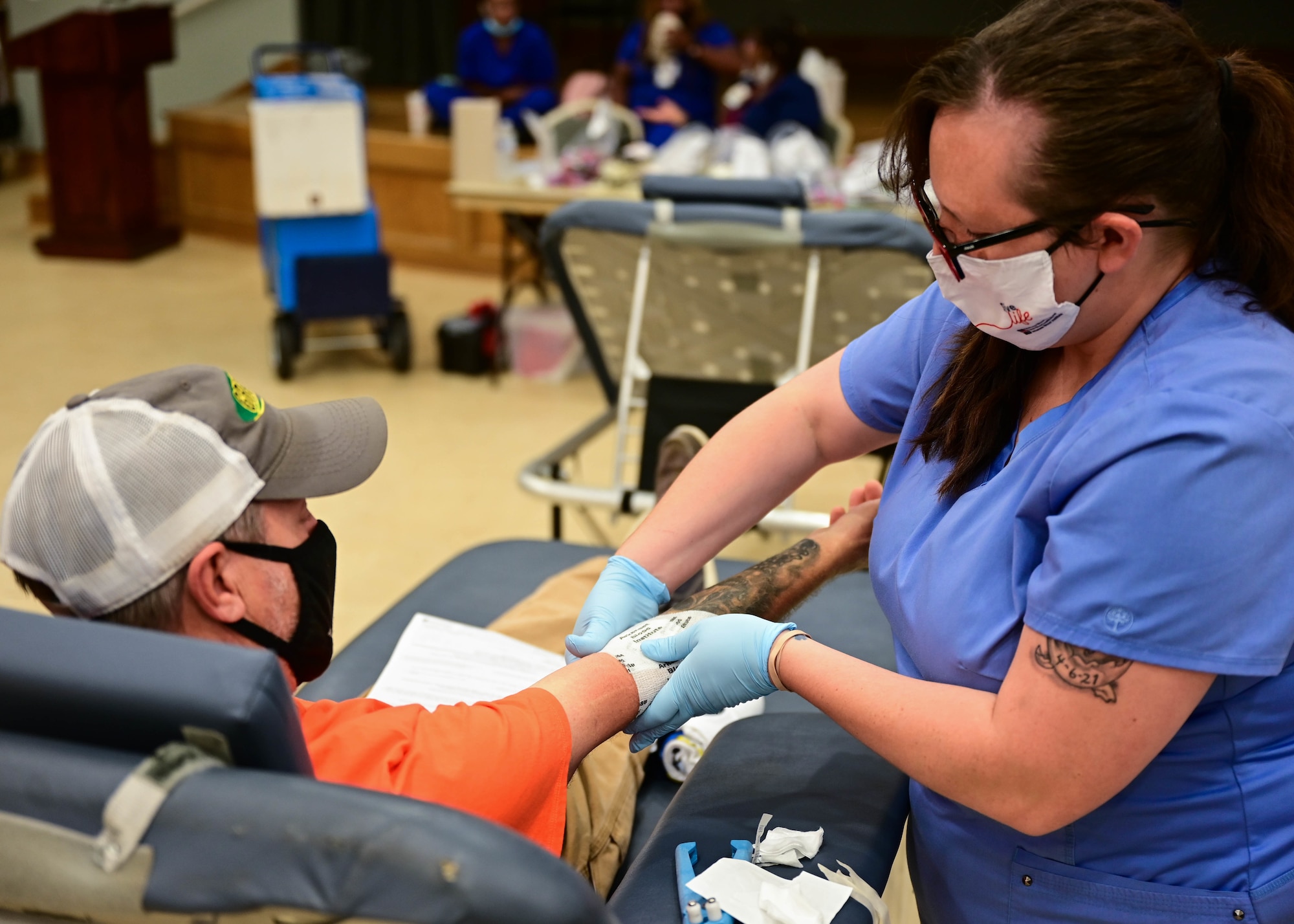 A phlebotomist from the Arkansas Blood Institute wraps up a volunteer’s arm during a blood drive