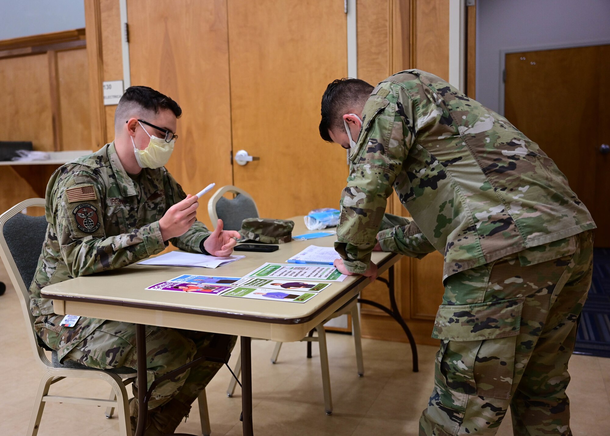 Two Airmen from the 19th Airlift Wing participate in the monthly base blood drive