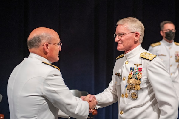 Chief of Naval Operations Adm. Mike Gilday, left, shakes the hand of Vice Adm. John G. Hannink during a change of office ceremony at the U.S. Naval Academy.