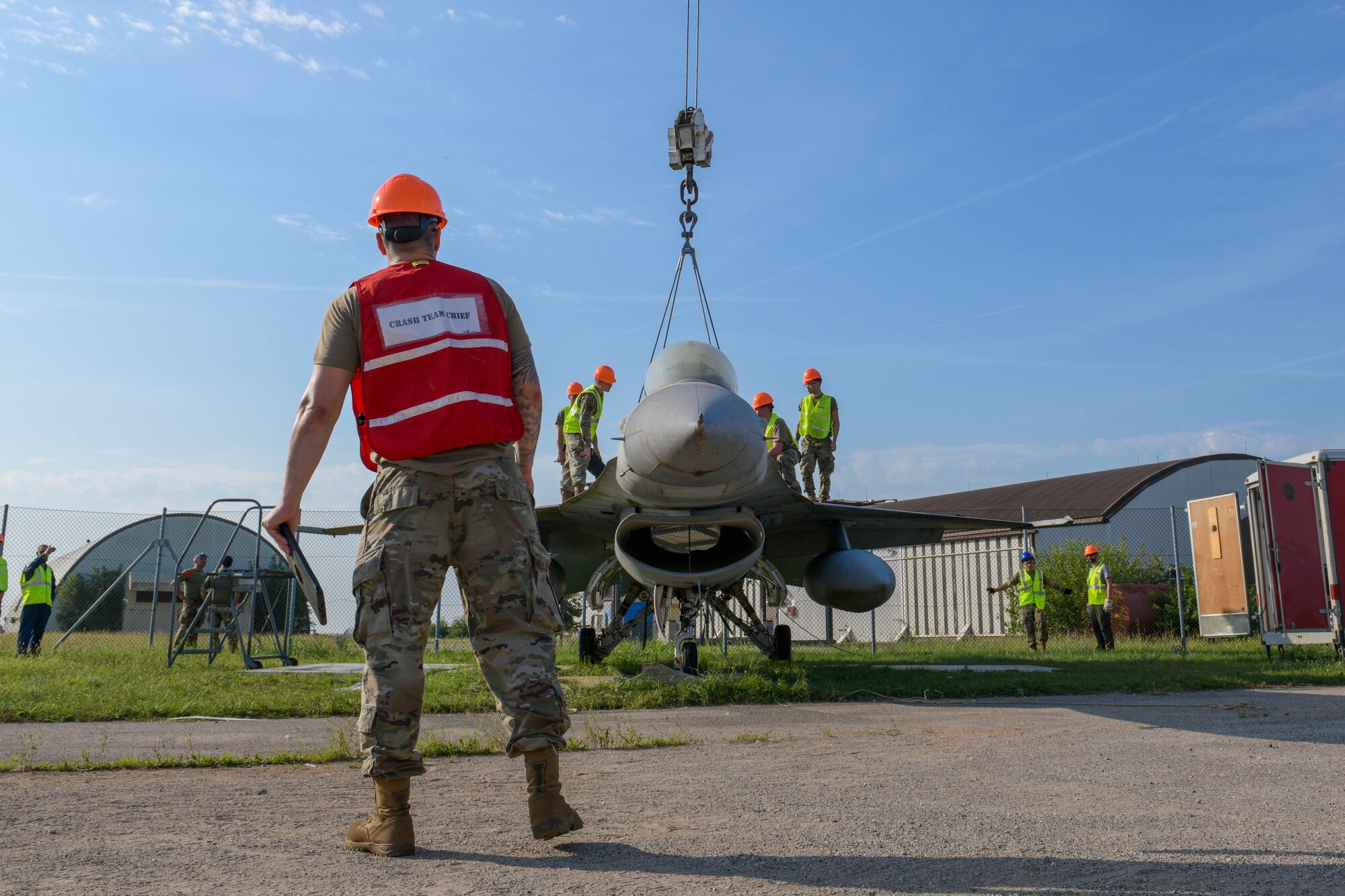 A U.S. Airman assigned to the 52nd Maintenance Squadron watches over a U.S. Air Force F-16 Fighting Falcon during an annual Crash, Damaged or Disabled Aircraft Recovery (CDDAR) lift certification at Aviano Air Base, Italy, Aug. 13, 2021. The crash recovery teams recertify annually on the correct procedures of lifting an aircraft during an emergency. Examples of an emergency during an aircraft flight include collapsed landing gear or an aircraft crash. (U.S. Air Force photo by Senior Airman Brooke Moeder)