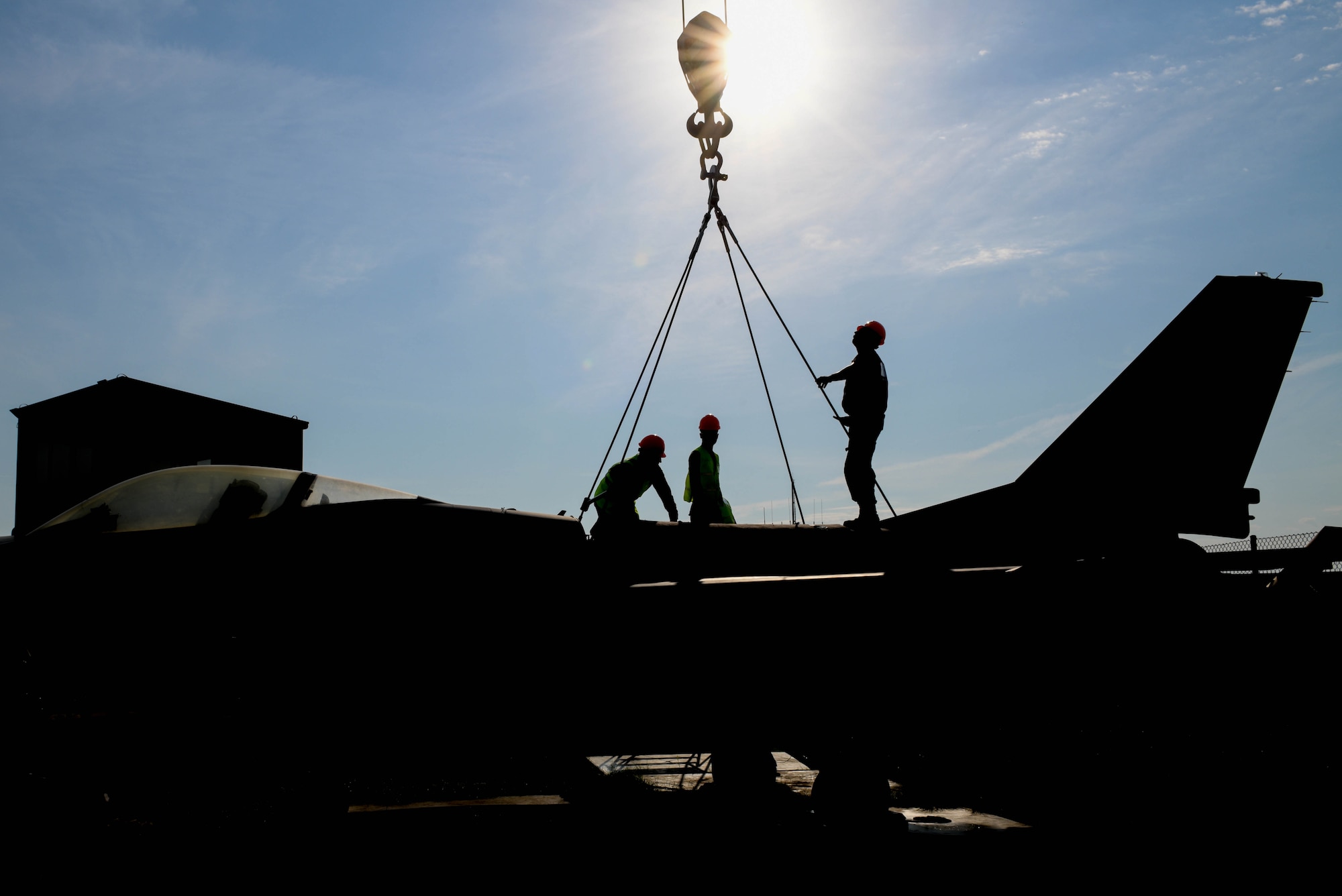 U.S. Airmen assigned to the 31st Maintenance Squadron (MXS) and 52nd MXS attach a lifting sling onto a U.S. Air Force F-16 Fighting Falcon at Aviano Air Base, Italy, Aug. 13, 2021. Airmen assigned to the 31st MXS and 52nd MXS performed an annual Crash, Damaged or Disabled Aircraft Recovery (CDDAR) lift certification to recertify on the correct procedures of lifting an aircraft during an emergency. The lifting sling was used to keep the F-16 stable during the lift. (U.S. Air Force photo by Senior Airman Brooke Moeder)