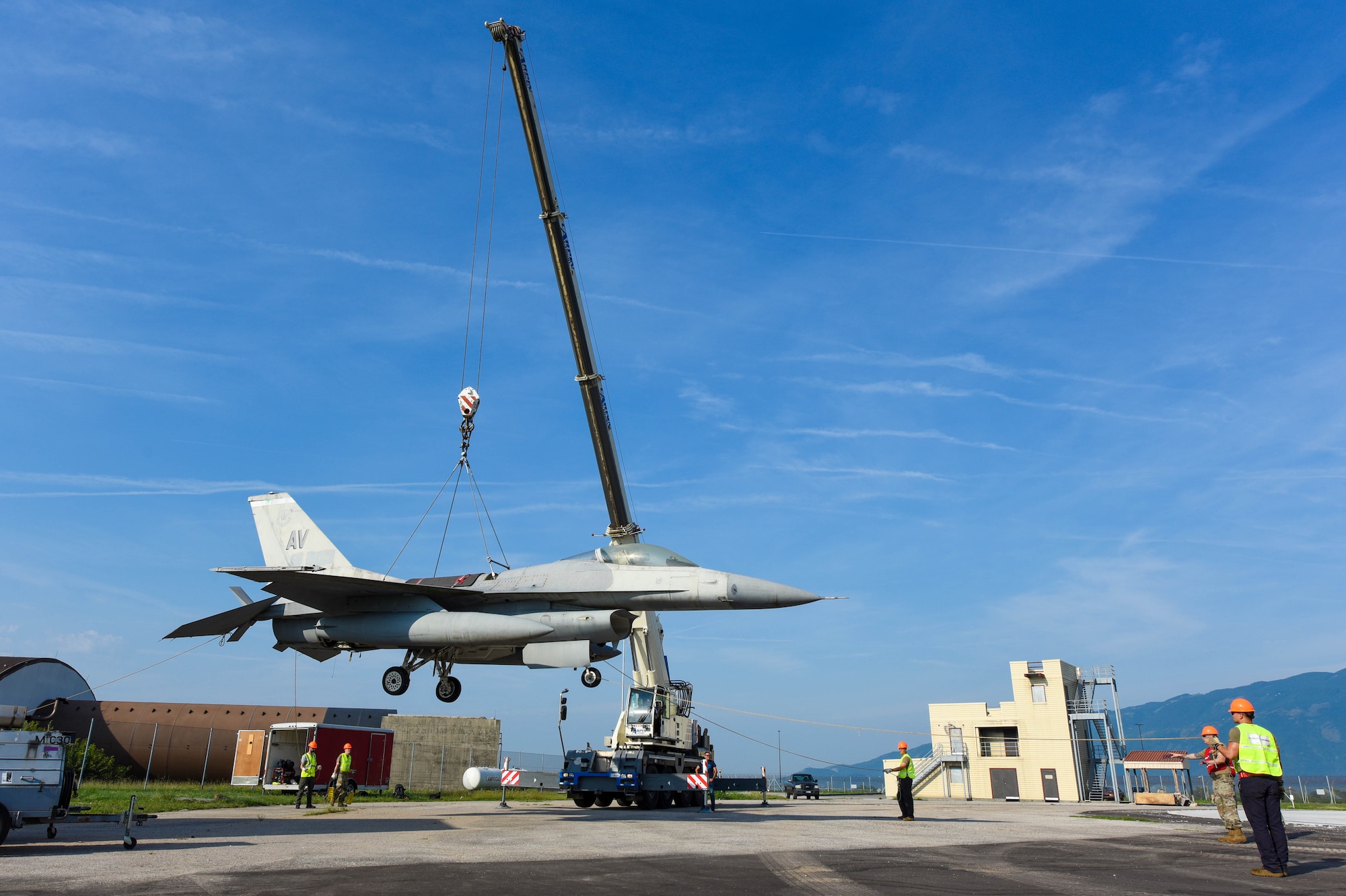 A U.S. Air Force F-16 Fighting Falcon is lifted from the ground during an annual Crash, Damaged or Disabled Aircraft Recovery (CDDAR) lift certification at Aviano Air Base, Italy, Aug. 13, 2021. The purpose of a real-world crash damaged disabled aircraft recovery is to clear the runway as safely and quickly as possible while causing no further damage to the aircraft. (U.S. Air Force photo by Senior Airman Brooke Moeder)