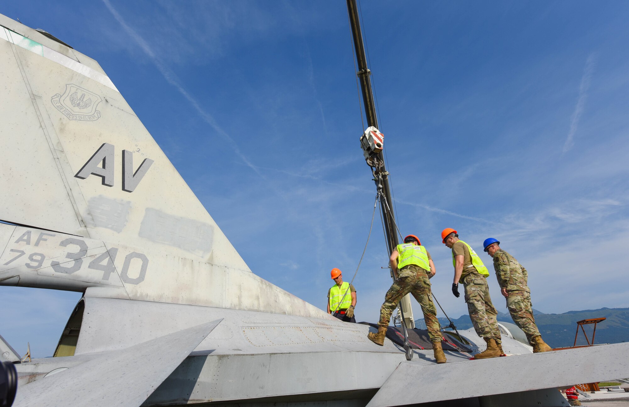U.S. Airmen assigned to the 31st Maintenance Squadron (MXS) and 52nd MXS attach a crane to a U.S. Air Force F-16 Fighting Falcon at Aviano Air Base, Italy, August 13, 2021. The Airmen participated in an annual Crash, Damaged or Disabled Aircraft Recovery (CDDAR) lift certification to recertify on the correct procedures of lifting an aircraft during an emergency. The purpose of a real-world crash damaged disabled aircraft recovery is to clear the runway as safely and quickly as possible while causing no further damage to the aircraft. (U.S. Air Force photo by Senior Airman Brooke Moeder)