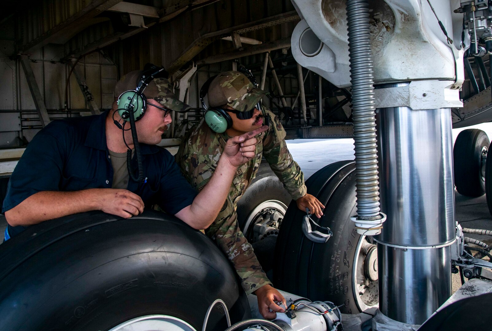 Staff Sgt. Dylan King, left, 436th Aircraft Maintenance Squadron crew chief, trains Airman 1st Class Joel Randley, 436th AMXS crew chief, on how to service a landing gear on the C-5M Super Galaxy at Dover Air Force Base, Delaware, Aug. 18, 2021. The 436th AMXS Airmen are responsible for the inspection, repair, launch and recovery of Dover AFB’s fleet of C-5M Super Galaxy aircraft. (U.S. Air Force photo by Senior Airman Stephani Barge)