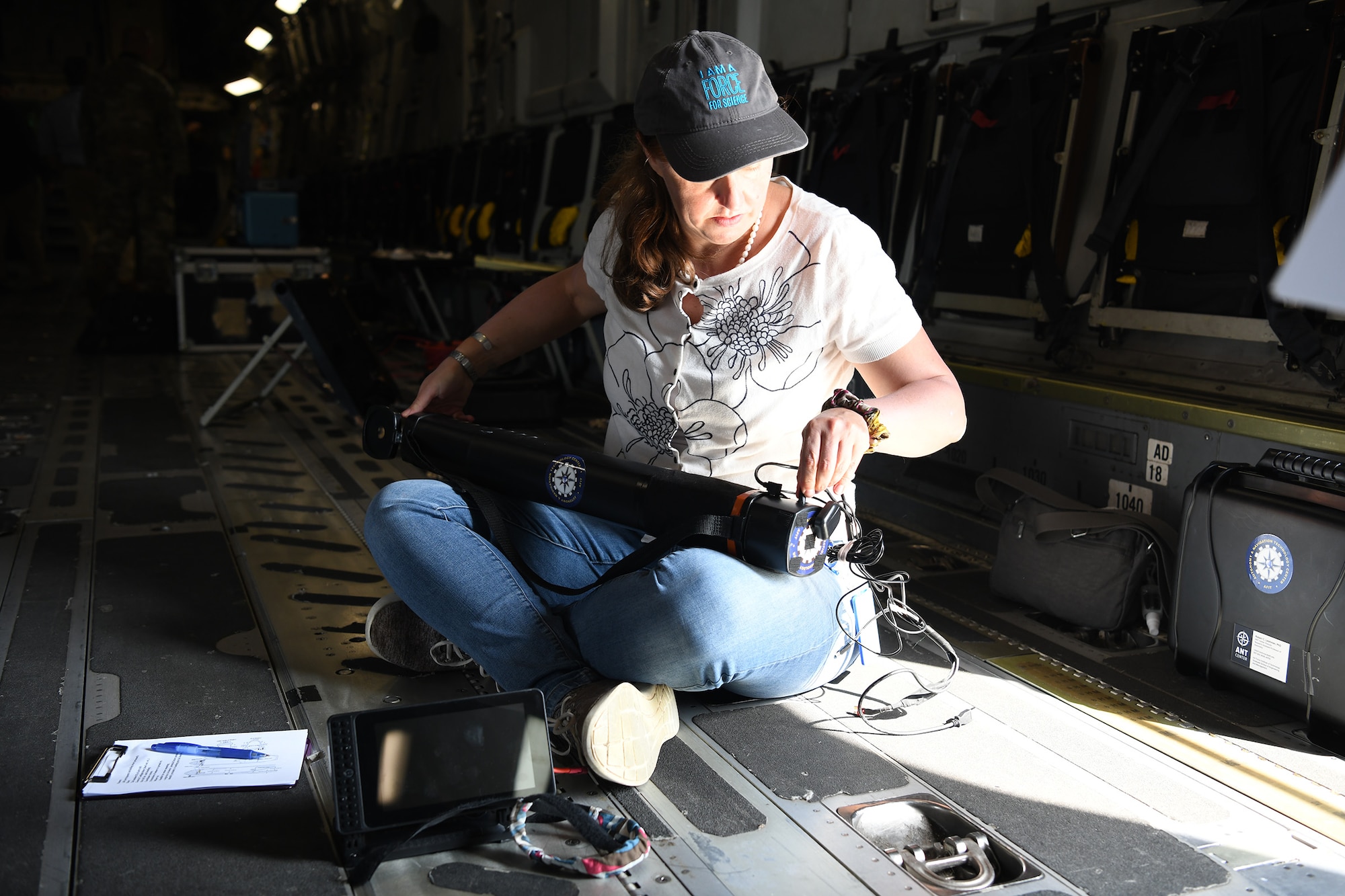 Evelyn Boettcher, an Air Force Institute of Technology contractor, prepares a Mag in a Box, a navigation system for GPS denied environments, for testing on a 445th Airlift Wing C-17 Globemaster III Aug 6, 2021. A team from the Air Force Institute of Technology, Air Force Research Lab, and Department of the Air Force/Massachusetts Institute of Technology Artificial Intelligence Accelerator are working on magnetic-navigation research and brought a stand-alone sensor to test on the C-17 help characterize the platform.