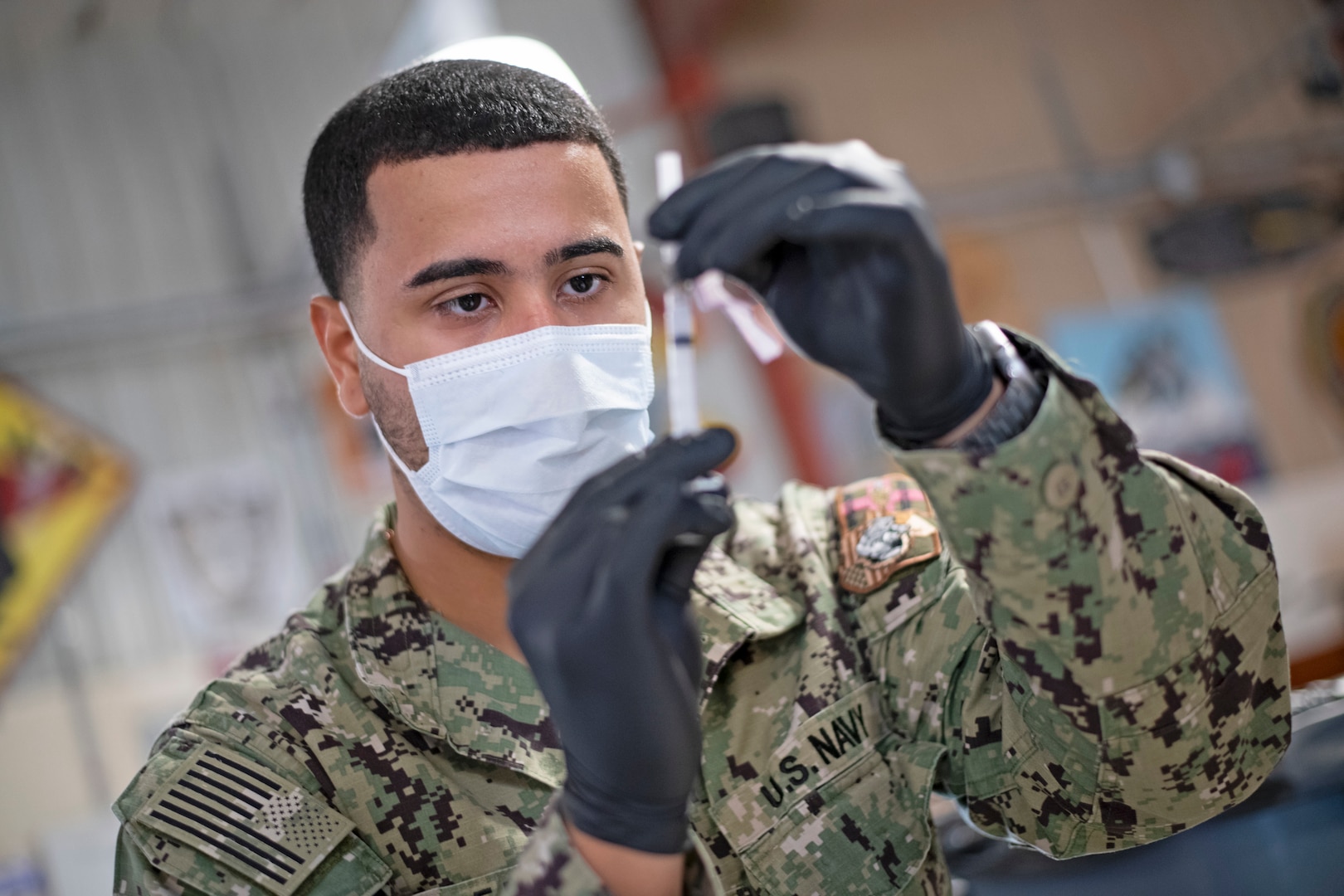 Service member prepares COVID-19 vaccine supplies