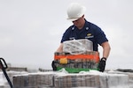 Lt. William Singletary, operations officer aboard the Cutter Eagle, moving pallets summer 2021. U.S. Coast Guard photo.