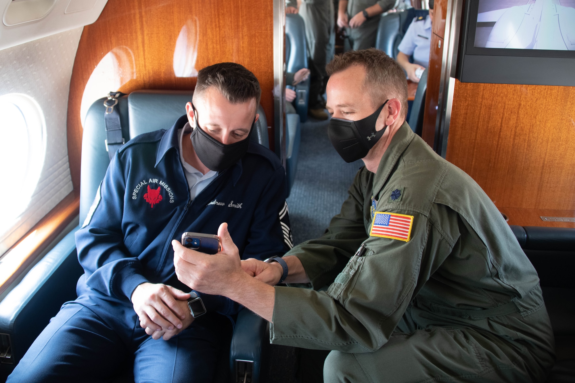 U.S. Air Force Lt. Col. Russell James, 99th Airlift Squadron (AS) pilot, shows Senior Master Sgt. Andrew Smith, 99th AS senior enlisted leader, photos from his last flight on the C-37B on Altus Air Force Base, Oklahoma, Aug. 13, 2021.  The 99th AS directly supports the U.S. vice president, members of the cabinet, Congress, and other domestic and foreign dignitaries. (U.S. Air Force photo by Airman 1st Class Trenton Jancze)