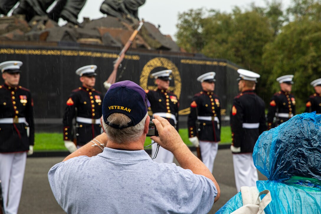 A veteran takes a photo during an Honor Flight performance by the Silent Drill Platoon at the Marine Corps War Memorial, Arlington, Va., Aug. 18, 2021. The Honor Flight Network is a national network whose mission is to transport America’s veterans to Washington, D.C. to visit memorials dedicated to honoring those who have served and sacrificed for our country. (U.S. Marine Corps photo by Lance Cpl. Tanner D. Lambert)