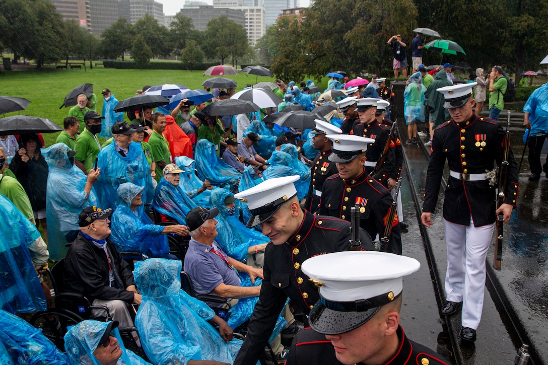 Marines with the Silent Drill Platoon greet veterans following an Honor Flight performance at the Marine Corps War Memorial, Arlington, Va., Aug. 18, 2021. The Honor Flight Network is a national network whose mission is to transport America’s veterans to Washington, D.C. to visit memorials dedicated to honoring those who have served and sacrificed for our country. (U.S. Marine Corps photo by Lance Cpl. Tanner D. Lambert)