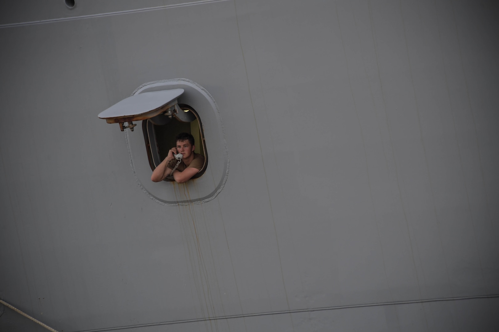 NAVAL STATION NORFOLK (Aug. 17, 2021) A Sailor stands watch aboard the amphibious transport dock ship USS Arlington (LPD 24) as the ship prepares to depart Naval Station Norfolk.  Arlington will support humanitarian assistance and disaster relief (HADR) efforts in Haiti following a 7.2-magnitude earthquake on Aug. 14, 2021. (U.S. Navy photo by Mass Communication Specialist 1st Class Jacob Milham)