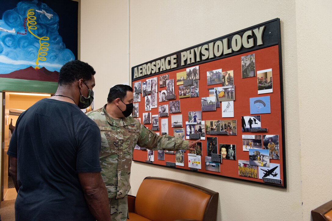 U.S. Air Force TSgt Abel Pelayo Ruelas, 47th Operations Support Squadron aerospace physiology technician, points out the rich history of the training program the squadron runs to Herschel Walker on Aug. 18, 2021 at Laughlin Air Force Base, Texas.  The purpose of the program is to mentally and physically prepare student pilots for flight for their health and safety. (U.S. Air Force photo by Airman Kailee Reynolds)