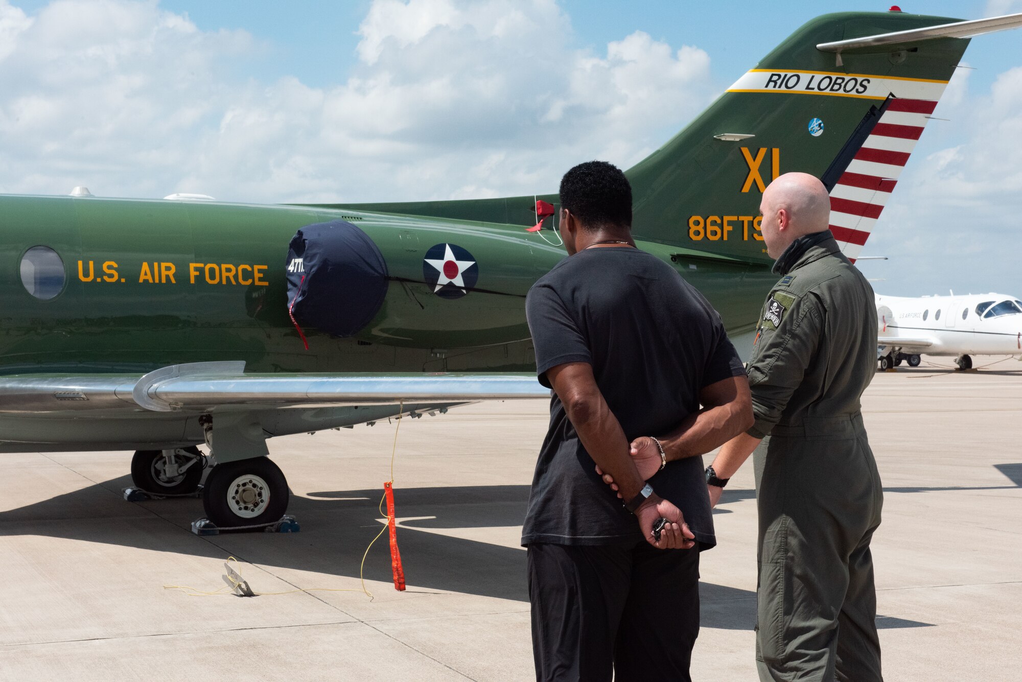 U.S. Air Force Capt. Jeff Babb, 47th Flying Training Wing instructor pilot, introduces Herschel Walker to the new 86th Flying Training Wing Heritage Tail out on the flightline on Aug. 18, 2021, at Laughlin Air Force Base, Texas. The heritage tail was created as a symbol of the wing's history and for the purpose of boosting the morale and pride of those included in the wing. (U.S. Air Force photo by Airman Kailee Reynolds)