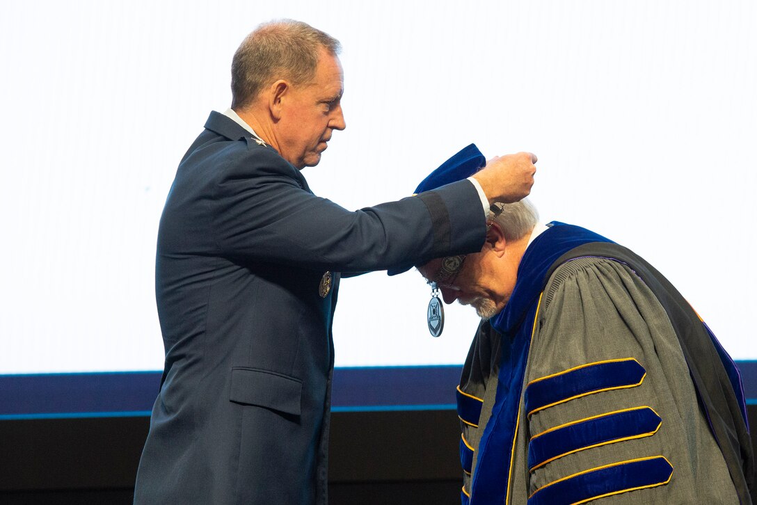U.S. Air Force Lt. Gen. James Hecker, Air University commander, places the Air Force institute of Technology Chain of Office around Walter Jones’s neck as he accepts the role of director and chancellor during an acceptance of leadership ceremony, July 27, 2021, at Wright-Patterson Air Force Base, Ohio. Jones is the 36th person to hold his position and only the second civilian. (U.S. Air Force photo by Wesley Farnsworth)