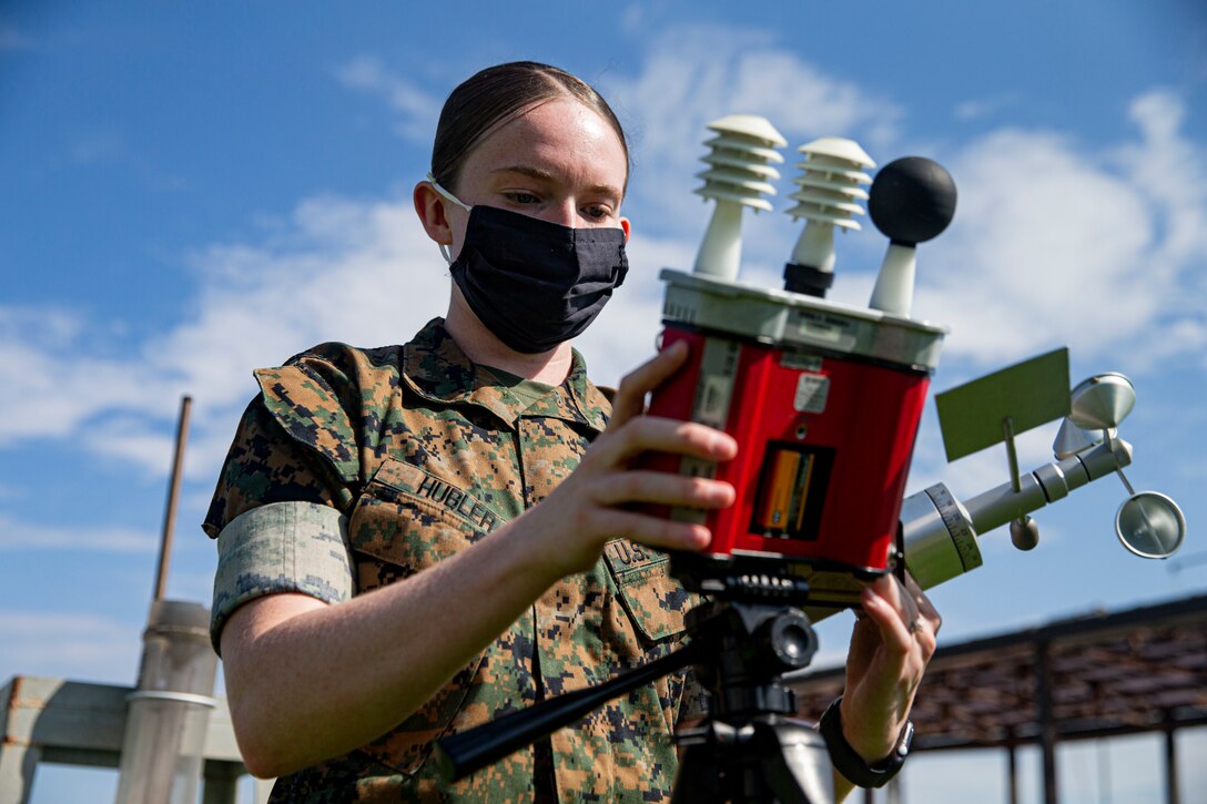 U.S. Marine Corps Cpl. Julia Hubler, a meteorological and oceanography (METOC) analyst forecaster with Headquarters and Headquarters Squadron, Marine Corps Air Station (MCAS) Futenma, measures the Wet Bulb Globe Index on MCAS Futenma, Okinawa, Japan, Aug. 9, 2021. METOC analyst forecasters analyze atmospheric, space, climatic and hydrologic intelligence which is used to make and brief tactical recommendations to commanders. Hubler is a native of Gore, Oklahoma. (U.S. Marine Corps photo by Lance Cpl. Alex Fairchild)