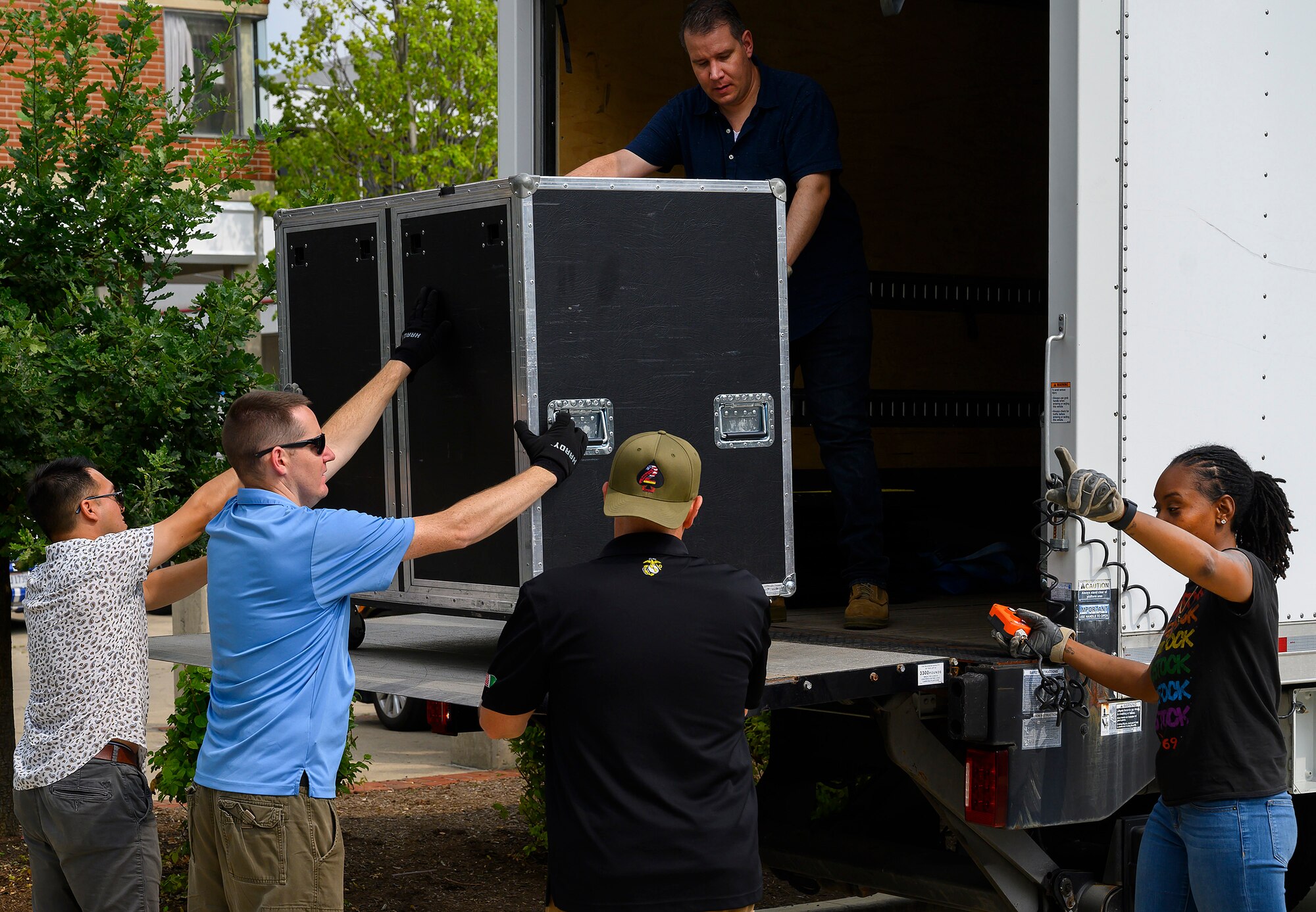 Members of the Air Force Band of Flight’s rock group Flight One unload their truck at Levitt Pavilion in Dayton, Ohio, on Aug. 7, 2021, to start setting up for a show. The group acts as its own roadies, hauling equipment, speakers and instruments from venue to venue. (U.S. Air Force photo by R.J. Oriez)